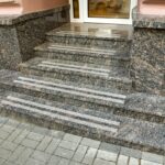 Schody granitowe prowadzą do wejścia do budynku.