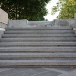 Schody z kamienia prowadzą na szczyt skweru otoczonego drzewami.